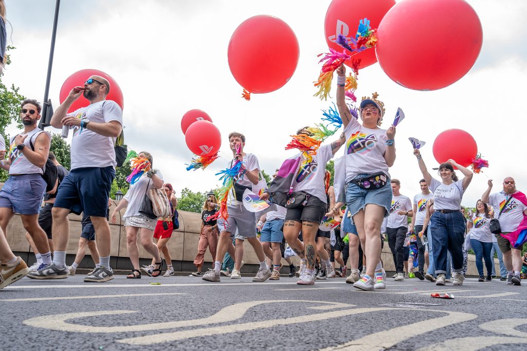 A group photo of London Sony Interactive employees walking at the London Pride parade.